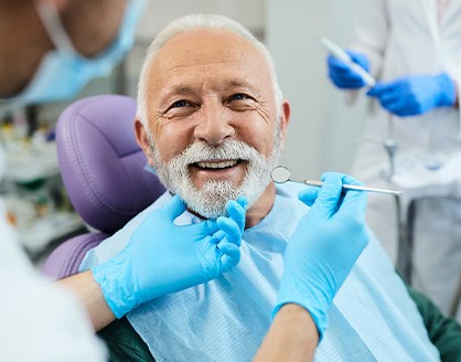 Man with white hair about to undergo dental exam