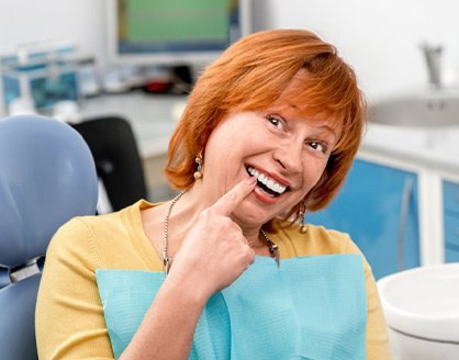 Woman pointing to her new dentures