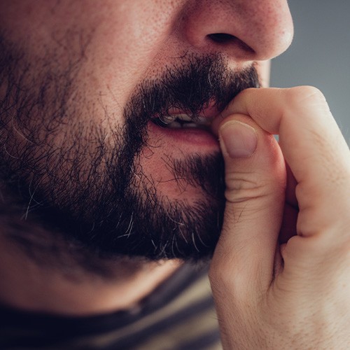 Closeup of man biting his nails