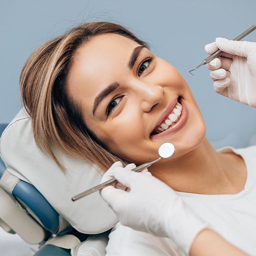 Smiling woman receiving dental treatment