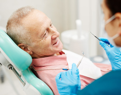 Patient smiling at dentist assistant in treatment room