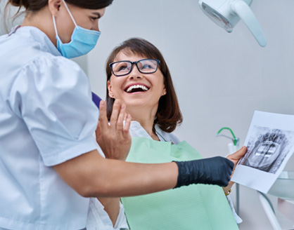 Dentist reviewing X-ray with smiling patient