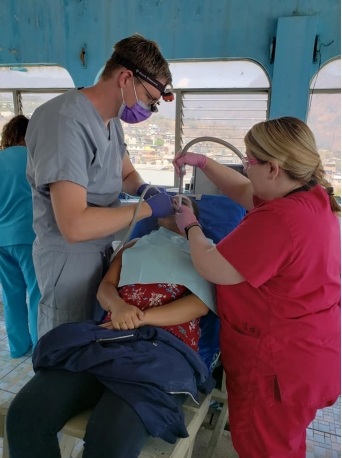 Dentist and team member treating dental patient