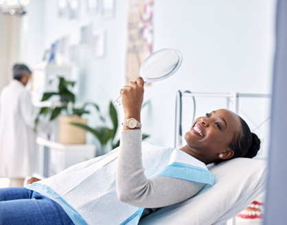 Woman smiling while looking at reflection in mirror