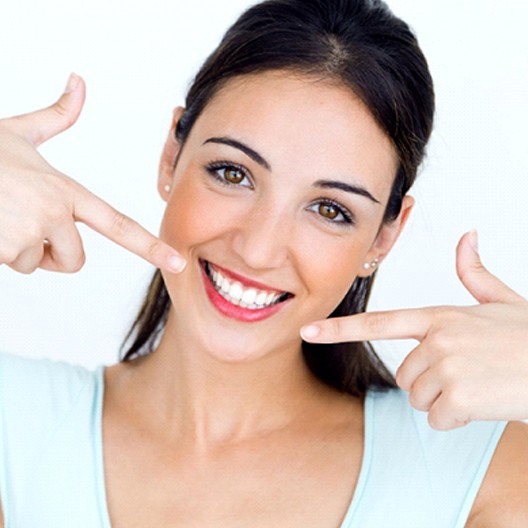 woman pointing to her smile