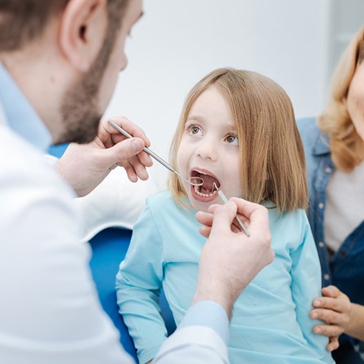 a child undergoing a dental checkup from her family dentist