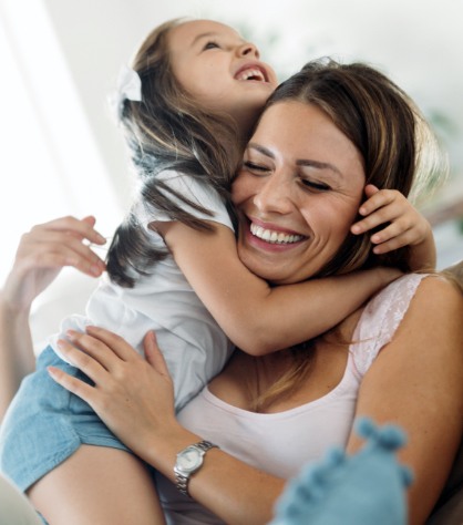 Mother hugging her daughter after children's dentistry