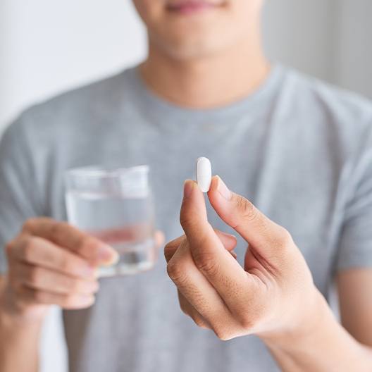 Man taking antibiotic periodontal treatment pill