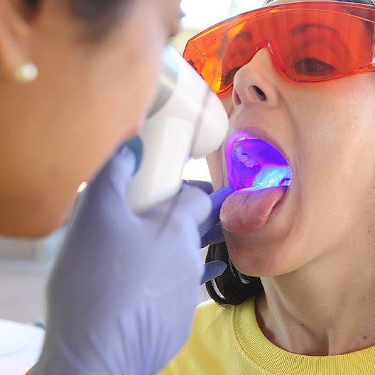 Dentist performing oral cancer screening