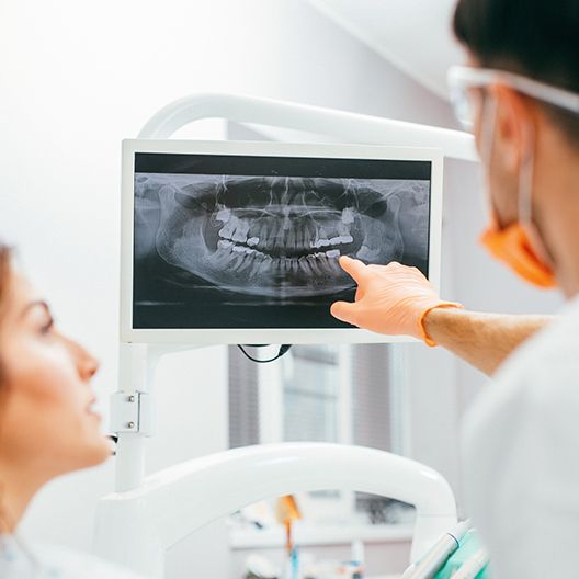 Dentist and patient looking at digital x-rays