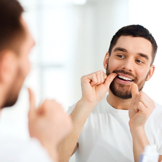 Closeup of man in white shirt flossing