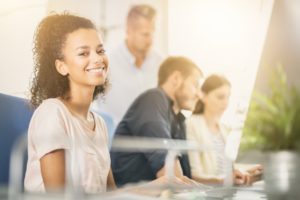 young millennial sitting at a desk and smiling