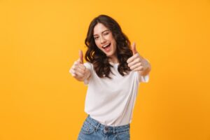 Woman smiling and holding two thumbs up